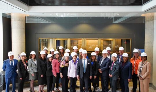 group photo of people wearing white hard hats