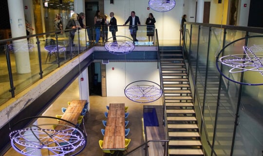 downward angle of staircase with concentric lights suspended from the ceiling